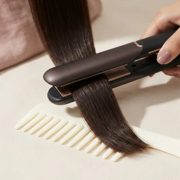 Prancha selando uma mecha de cabelo sobre pente ivory